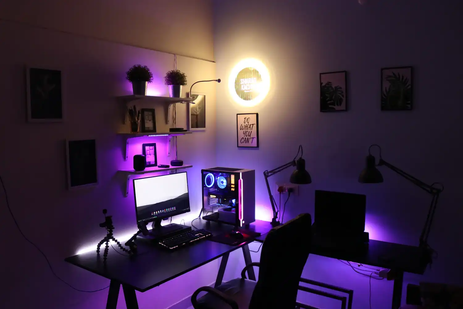 A dark room with a gaming PC and low purple lights